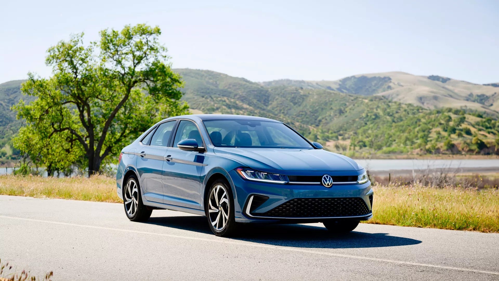 Blue 2026 VW Jetta driving on a country road