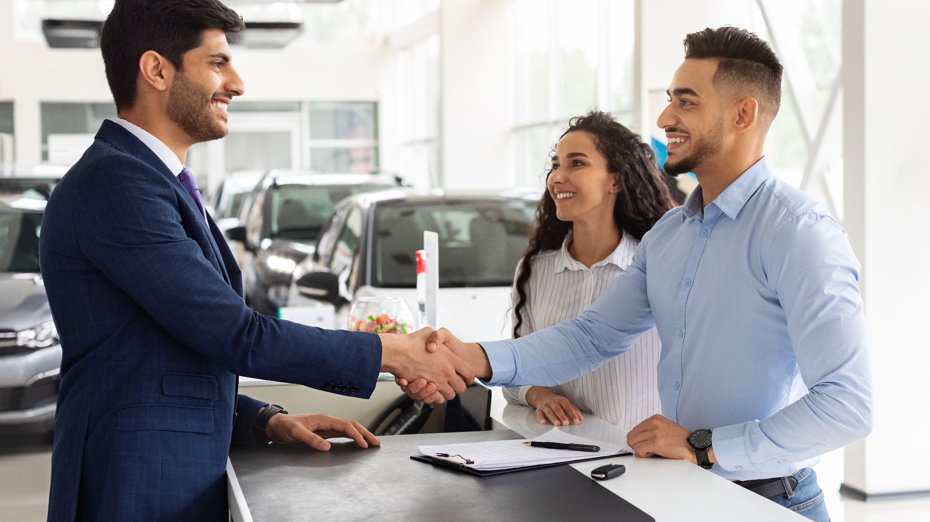 Couple shakes hands with a VW sales representative