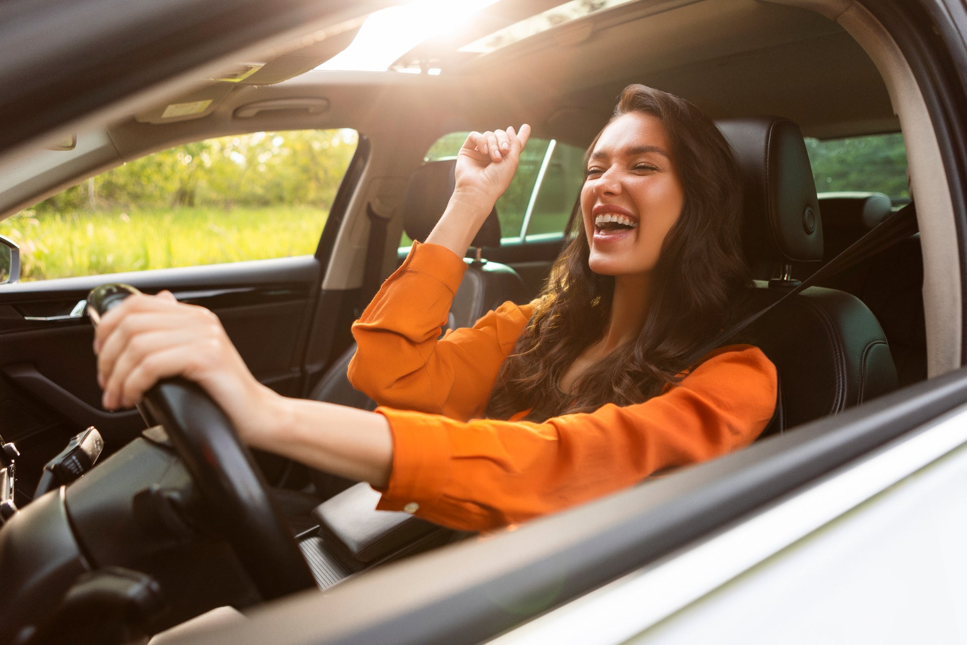 joyful young woman enjoying her new vehicles features
